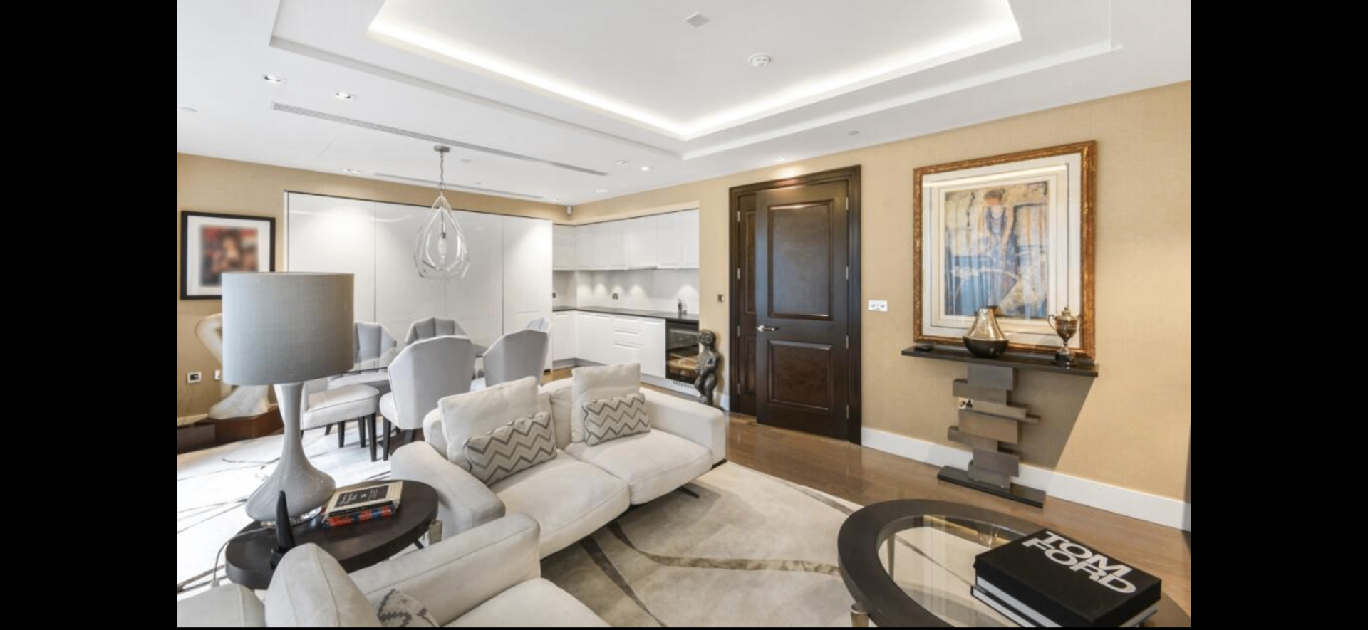 Luxurious open-plan London apartment reception room with cream sofas, modern kitchen and elegant decor